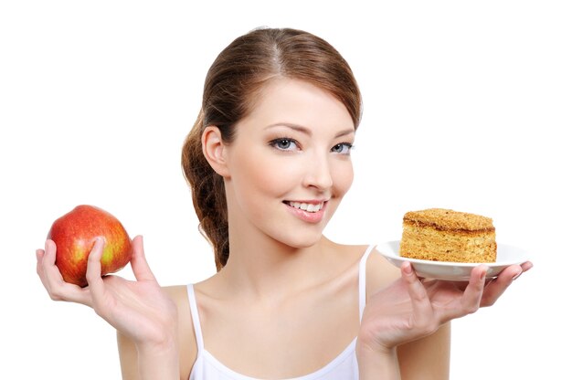 Young beautiful girl with fruit and cake in her hands
