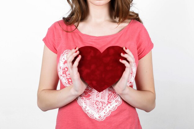 Young beautiful girl with long dark wavy hair in a pink shirt ho