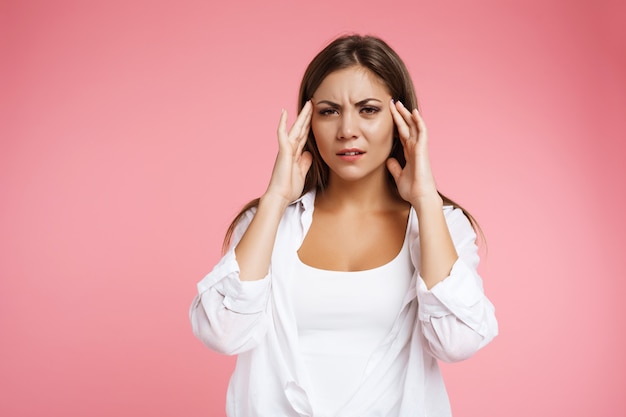 Young beautiful girl with strong tension headache holding headache