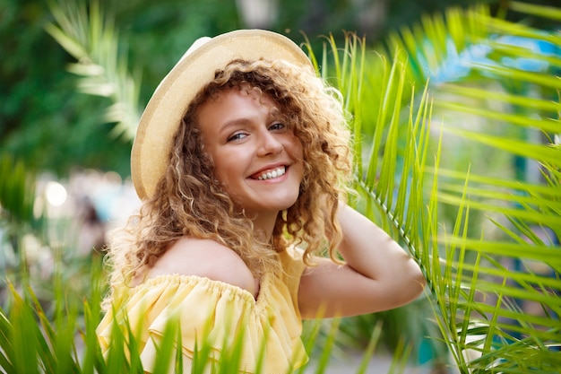 Young beautiful girl in yellow dress posing in city park.