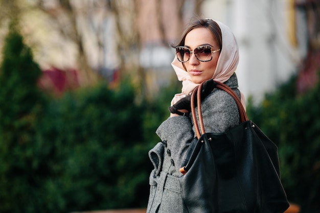 Free photo young beautiful happy woman in a coat posing at the park