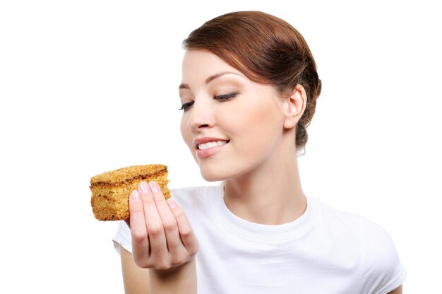 Молодая красивая счастливая женщина ест изолированный торт