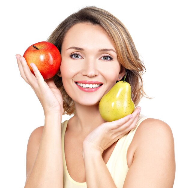 Young beautiful happy woman holds the apple and pear isolated on white.