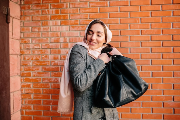 新しいバッグに非常に満足している若い美しい幸せな女