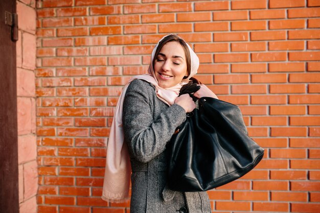 新しいバッグに非常に満足している若い美しい幸せな女