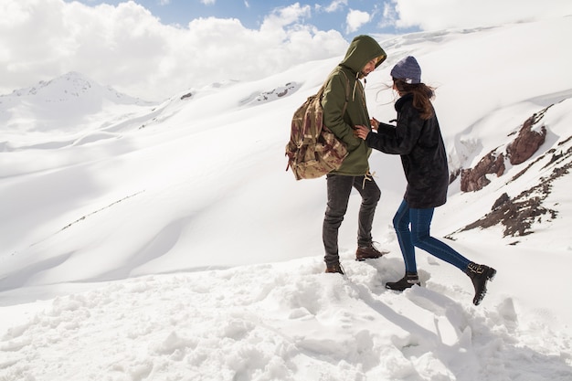 Young beautiful hipster couple hiking in mountains, winter vacation traveling, man woman in love