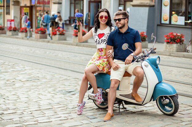 Young beautiful hipster couple riding on motorbike city street