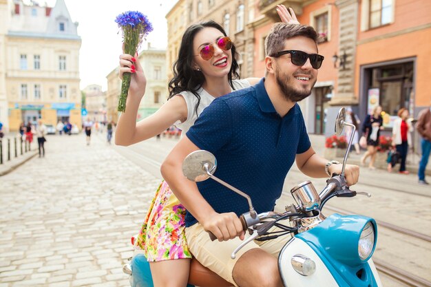 バイクの街の通りに乗って若い美しい流行に敏感なカップル