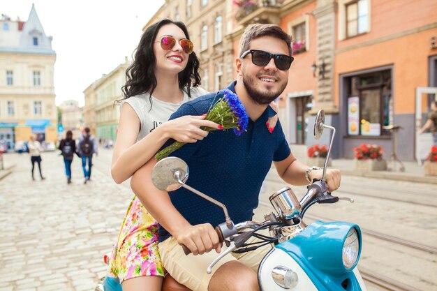バイクの街の通りに乗って若い美しい流行に敏感なカップル