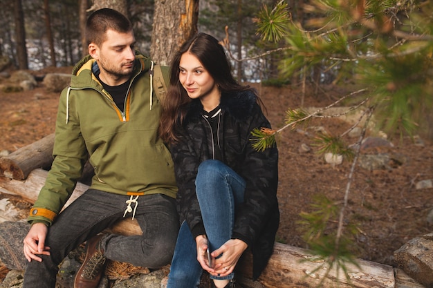 Young beautiful hipster man and woman in love traveling together in wild nature, hiking in forest