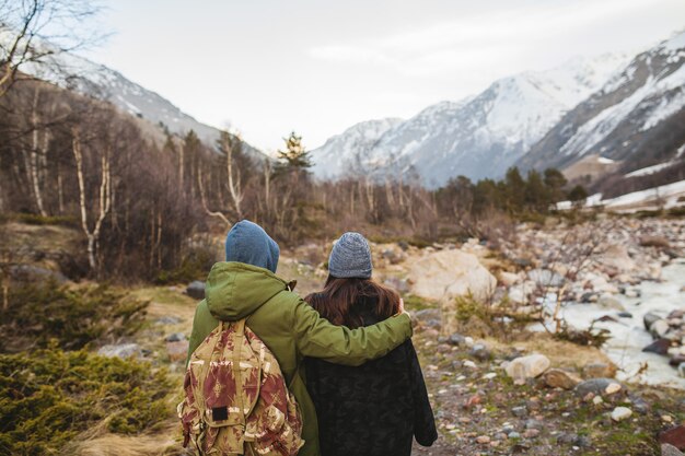 野生の自然の中で一緒に旅行する愛の若い美しいヒップな男と女