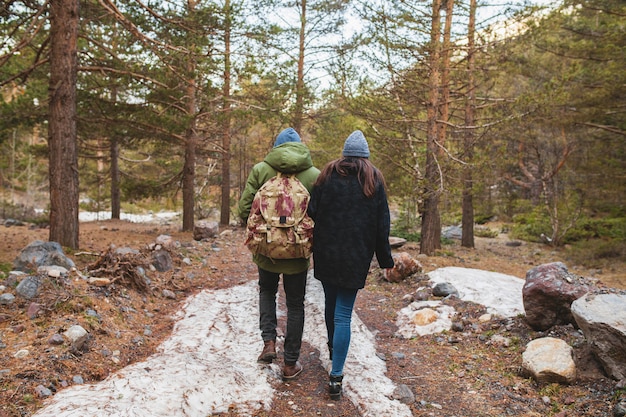 野生の自然の中で一緒に旅行する愛の若い美しいヒップな男と女