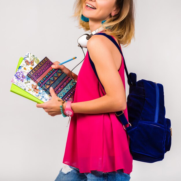 Young beautiful hipster woman, pink shoes and top holding books