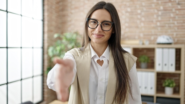 Free Photo young beautiful hispanic woman business worker smiling confident shake hand at office
