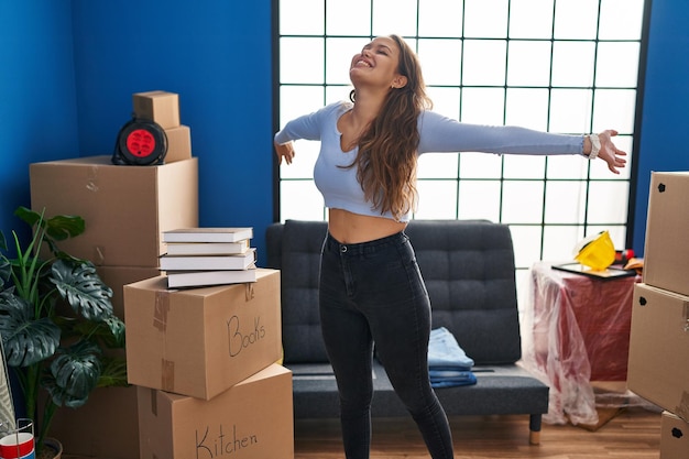 Young beautiful hispanic woman smiling confident standing at new home