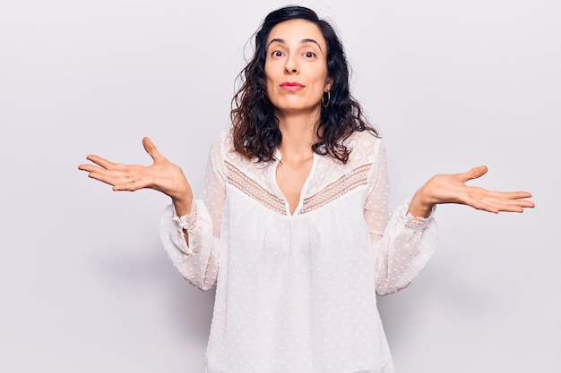 Free photo young beautiful hispanic woman wearing casual clothes clueless and confused expression with arms and hands raised doubt concept