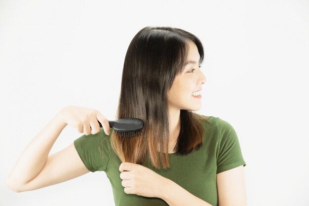 Young beautiful lady happy using comb to straight her hair - woman beauty hair care concept