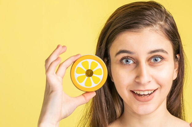 Young beautiful lady holding a round plastic and smiling for the camera