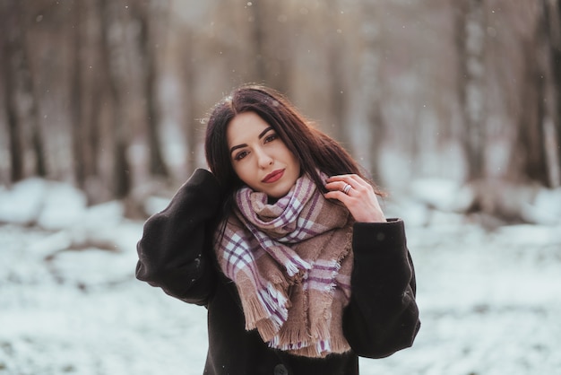 Young beautiful model posing in winter forest