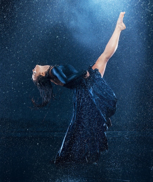 Бесплатное фото Молодая красивая современная танцовщица танцует под каплями воды
