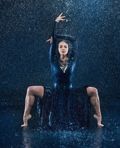 물 방울에서 춤추는 젊은 아름 다운 현대 댄서