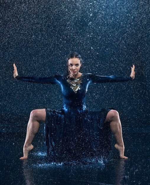 Free photo young beautiful modern dancer dancing under water drops