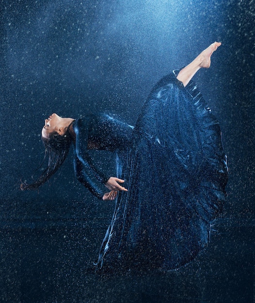 young beautiful modern dancer dancing under water drops