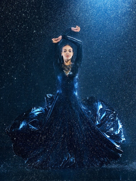 молодая красивая современная танцовщица танцует под каплями воды