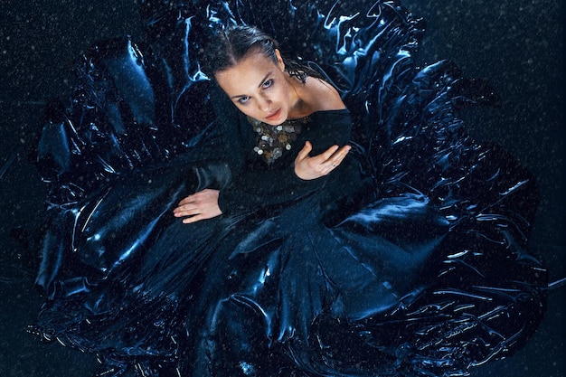 The young beautiful modern dancer posing under water drops