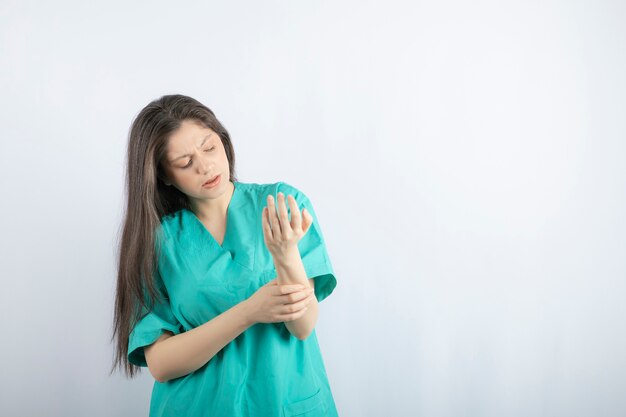 Young beautiful nurse checking her arm.