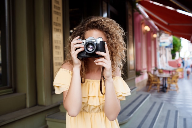 Free photo young beautiful photographer walking around city.