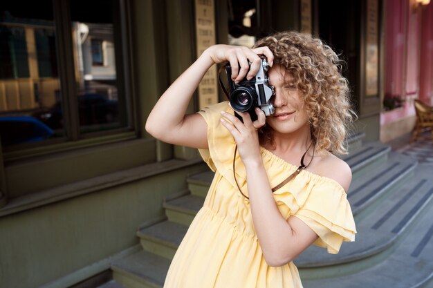 Young beautiful photographer walking around city.