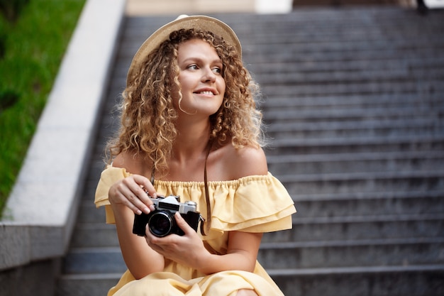 Free photo young beautiful photographer walking around city.