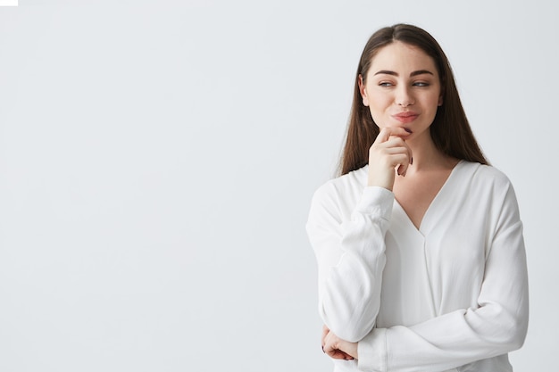 Young beautiful playful businesswoman with cunning tricky glance smiling .