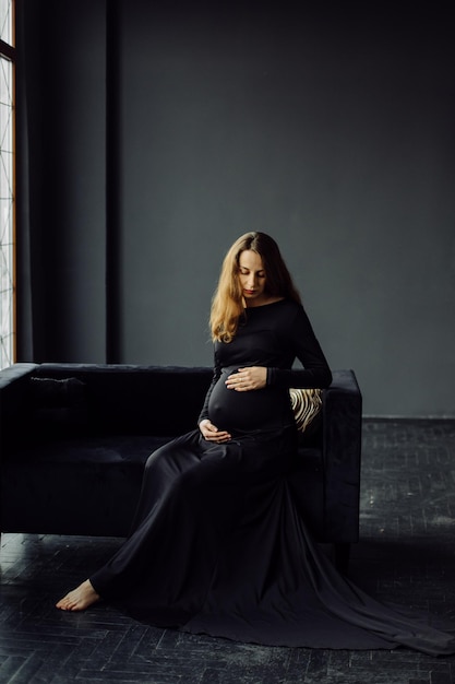 Young beautiful pregnant woman in black dress Pregnancy fashion look concept