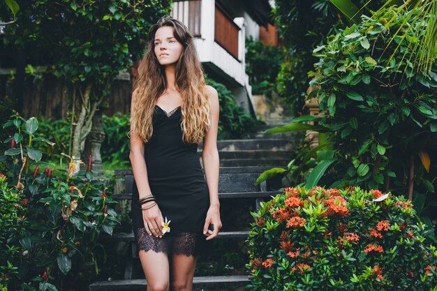 Young beautiful sexy woman in tropical garden, summer vacation in thailand, slim skinny tanned body, little black dress with lace, natural look, sensual, relaxed,