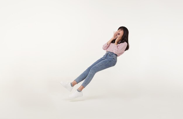 Young beautiful smiling asian girl floating in midair shout story and announcement something