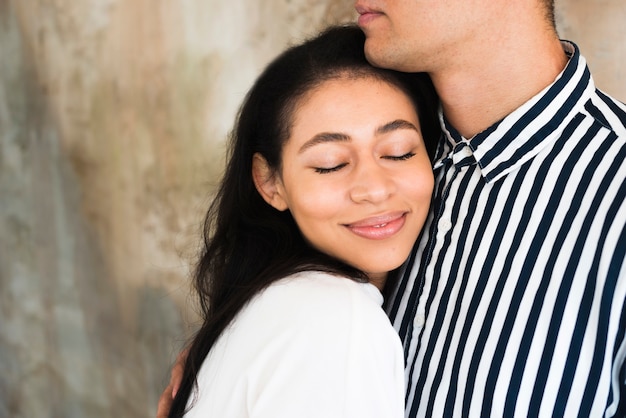 Young beautiful smiling female leaning on boyfriend