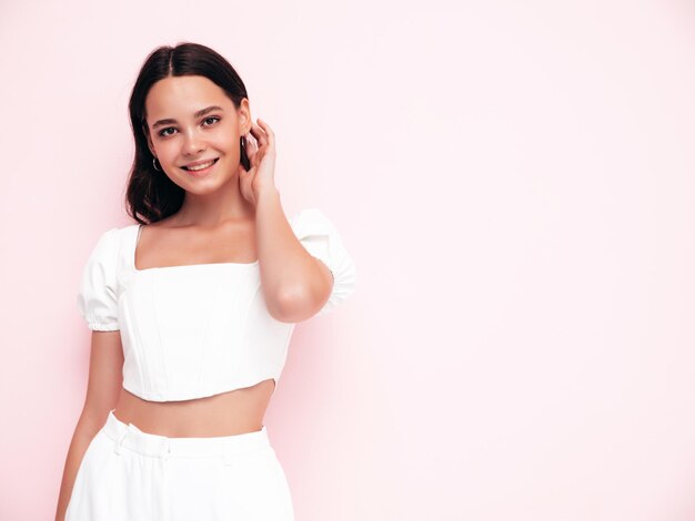 Young beautiful smiling female in trendy summer clothes Sexy carefree woman posing in studio Positive model having fun indoors