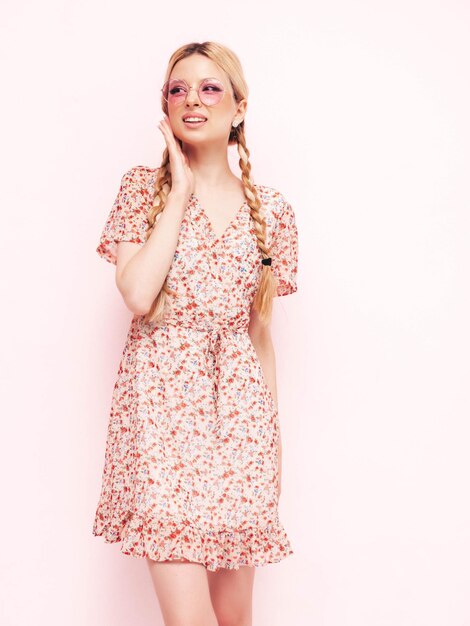 Young beautiful smiling female in trendy summer dress Sexy carefree blond woman posing near wall in studio Model having fun Cheerful and happy