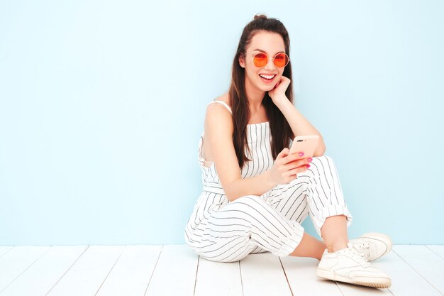 Young beautiful smiling female in trendy summer hipster clothes