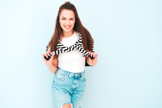 Young beautiful smiling female in trendy summer hipster clothes