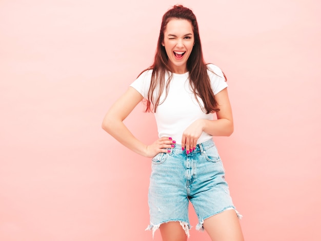 Young beautiful smiling female in trendy summer hipster clothes