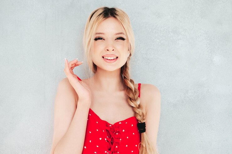無料Photo トレンディな夏の赤いドレスで若い美しい笑顔の女性スタジオの壁の近くでポーズをとるセクシーな屈託のないブロンドの女性