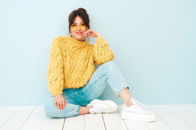 Young beautiful smiling female in trendy summer yellow hipster sweater and  jeans