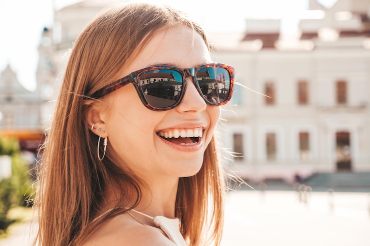 Free Photo young beautiful smiling hipster woman in trendy summer clothes sexy carefree woman posing on the street background at sunset positive model outdoors cheerful and happy in sunglasses