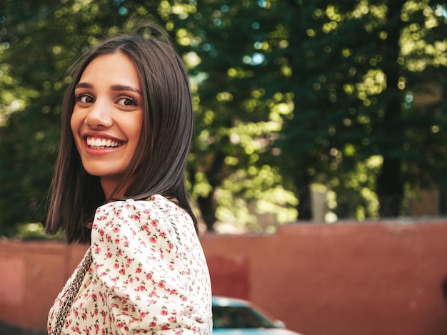 Young beautiful smiling hipster woman in trendy summer dress Sexy carefree woman posing on the street background at sunset Positive model outdoors Cheerful and happy