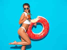 Free photo young beautiful smiling sexy woman in sunglasses. girl in white summer underpants and topic with donut lilo inflatable mattress. . drinking fresh cocktail smoozy drink