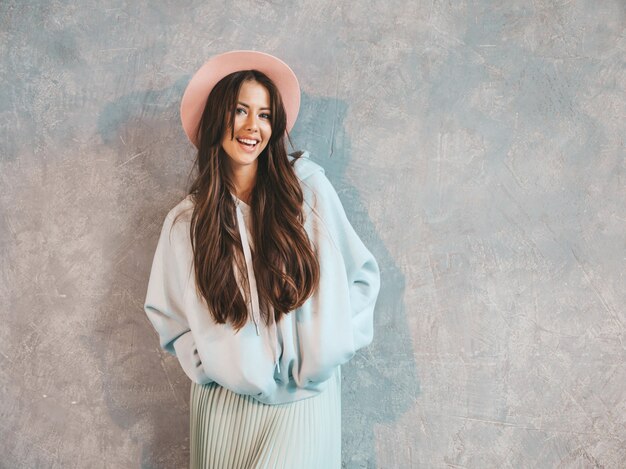 Young beautiful smiling woman looking . Trendy girl in casual summer hoodie and skirt clothes.  