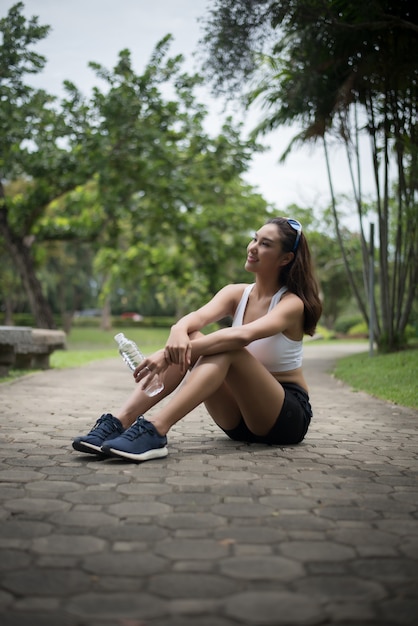 Young beautiful sport woman sit at the park after jog. Health and sport concept.